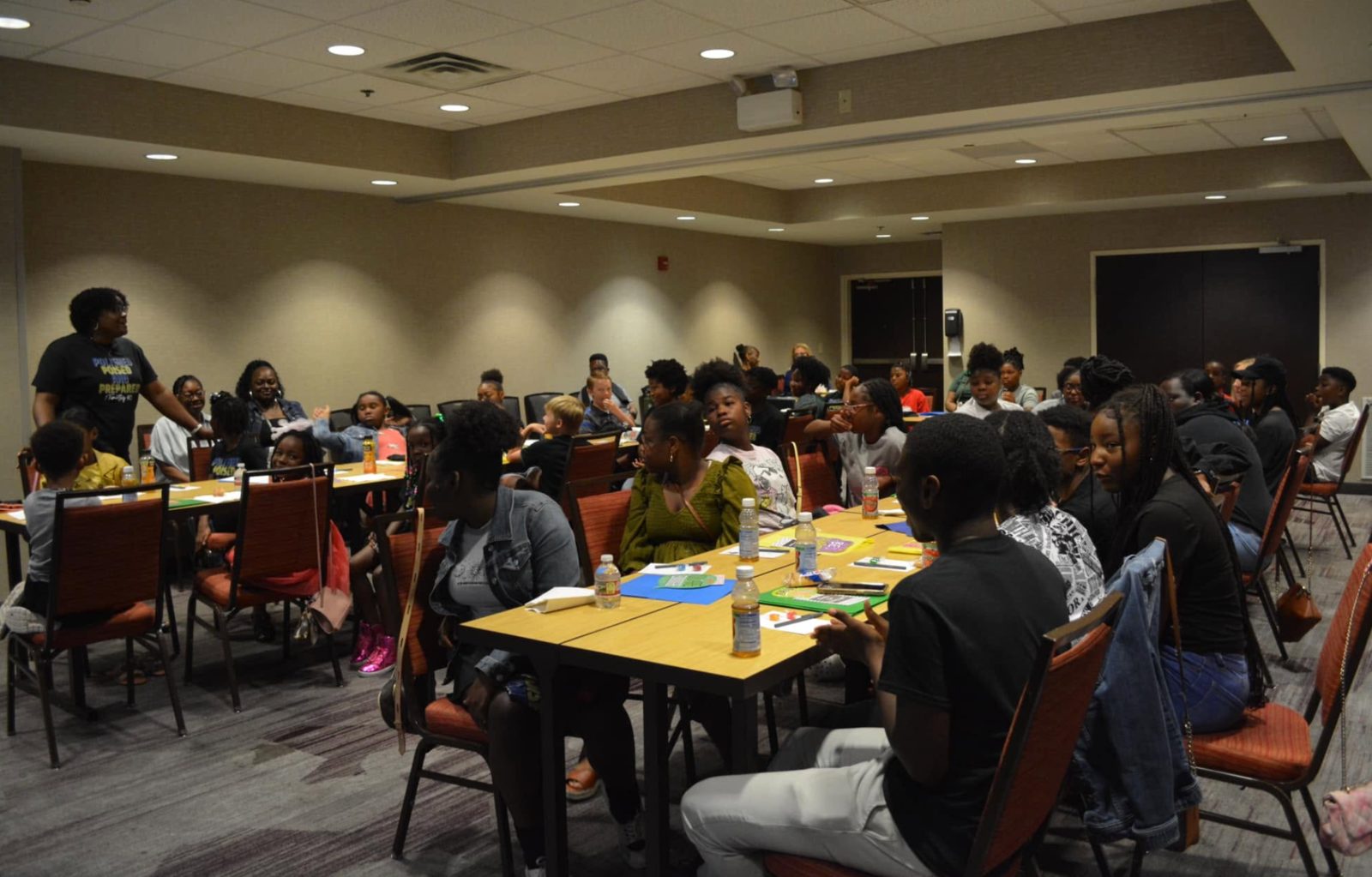 Amy Ogunyemi facilitating a workshop with students seated at tables