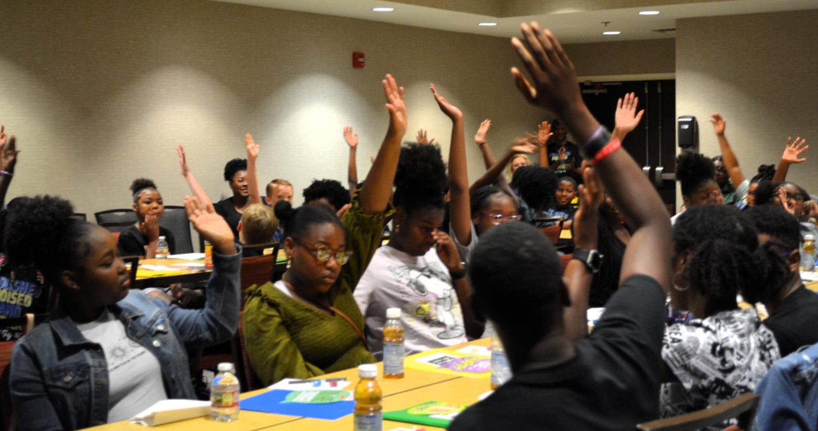 Students raising their hands during an interactive workshop session